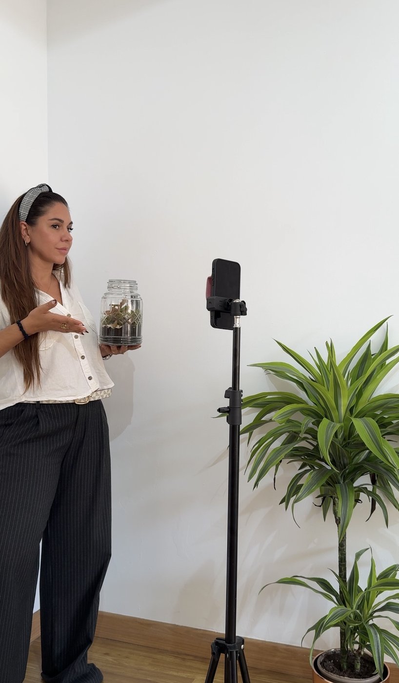 Elen grabando contenido con un producto en la mano frente a un móvil en trípode